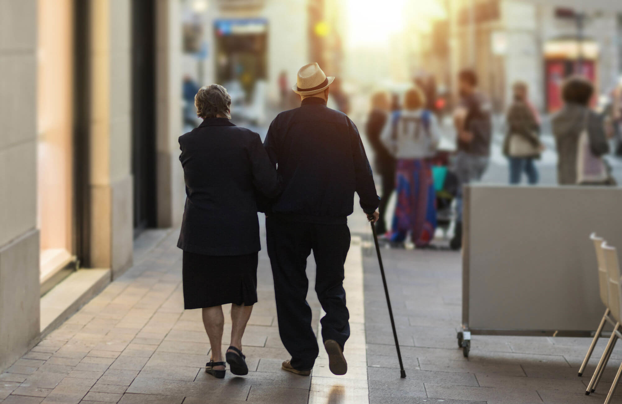 An older couple walking down a city sidewalk